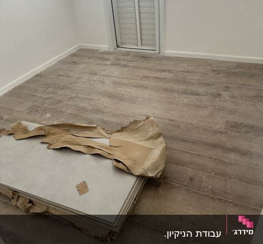 חדר עם רצפה מלוכלכת ואריזות קרטון על הרצפה